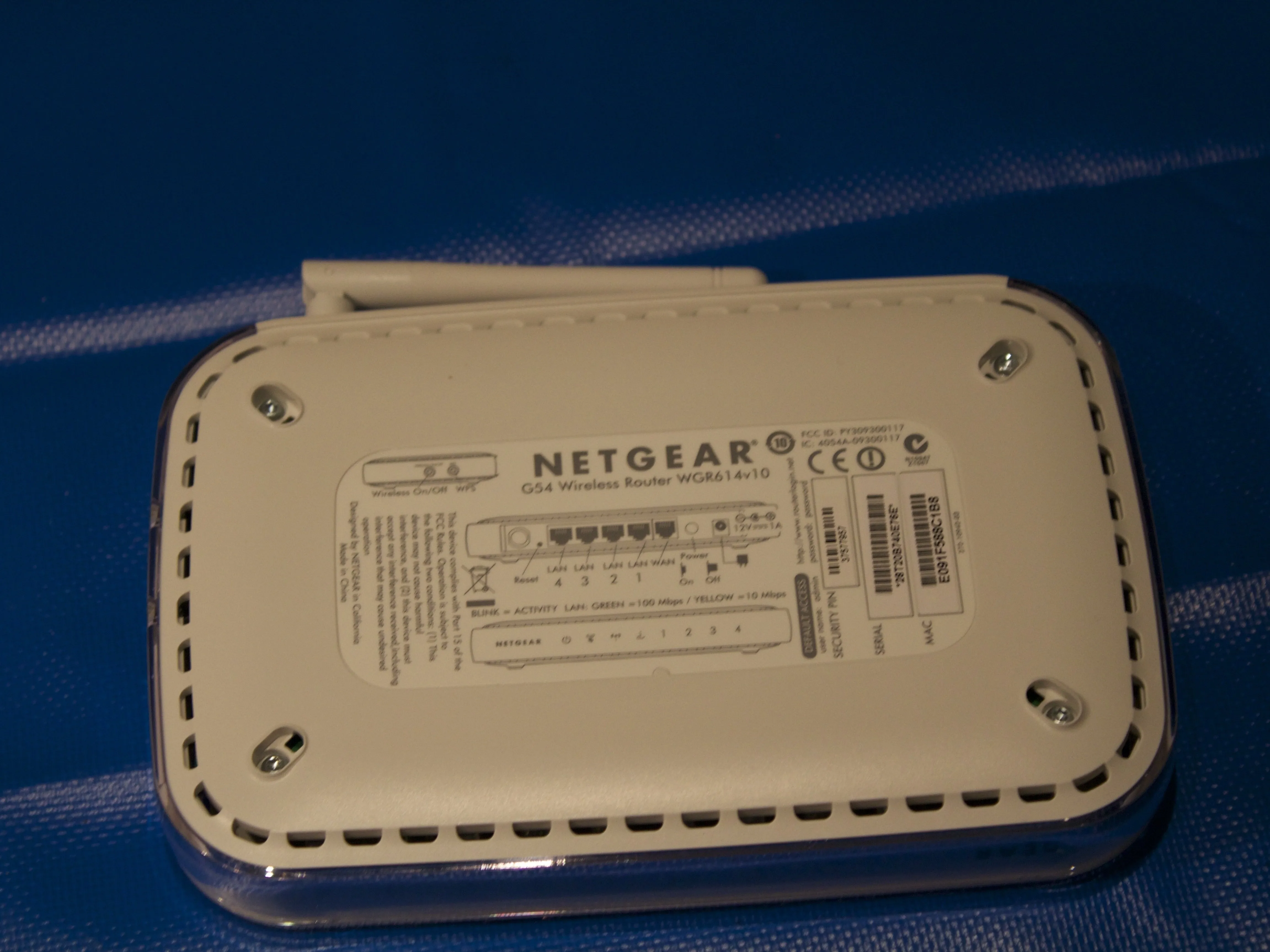 Разборка беспроводного маршрутизатора Netgear G54, удаление резиновых вкладок: шаг 2, изображение 1 из 1